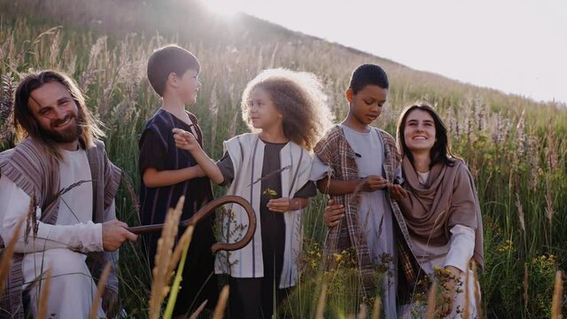 Jesus with stuff, children and Mary among the ears on the hill. Sun shining. They talk to each other and smiling. High quality 4k footage