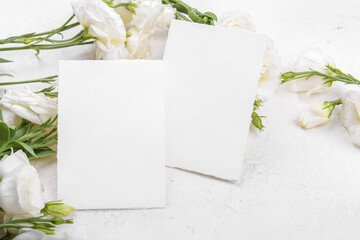 Two empty 5x3,5 card mockup with blooming white eustoma lisianthus flowers, design element for wedding invitation, thank you or greeting card. Spring background
