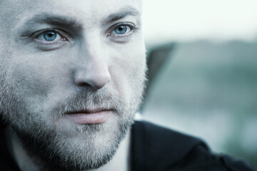Close-up portrait of a man with a serious face and a thoughtful look.