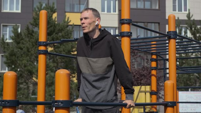 Fit Man Doing Push-ups on Parallel Bars Outdoors. Sport, Fitness, Street Workout and Healthy Lifestyle Concept