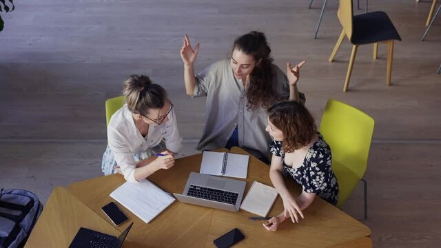 Female students discussing great ideas in library, high angle view