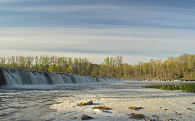 River Venta waterfall in sunny, misty spring morning, Kuldiga, Latvia.