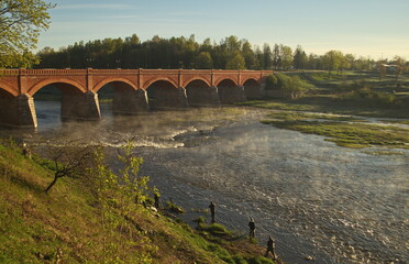 Long brick bridge in sunny spring morning, Kuldiga, Latvia. 