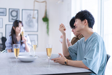 みんなで食事をする若い男女