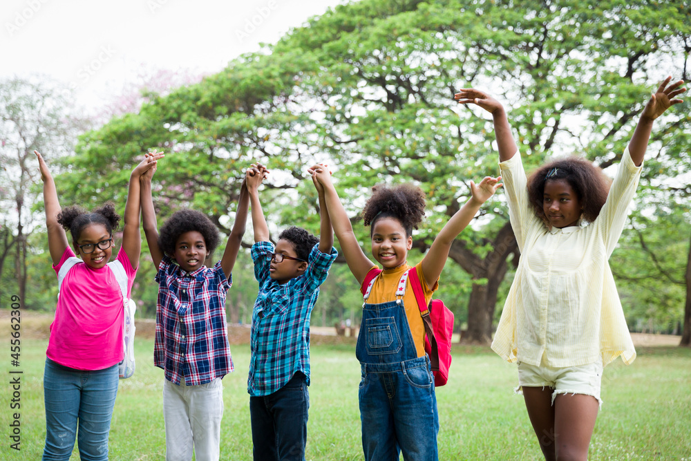 Sticker Group of African American children joining their hands in the park. Diverse black children joining their hands. Successful and teamwork concept