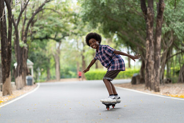 Happy child boy playing on roller blades, African American young boy riding on roller skates in the...