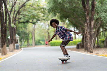 Happy child boy playing on roller blades, African American young boy riding on roller skates in the park, Kid playing on roller skates.