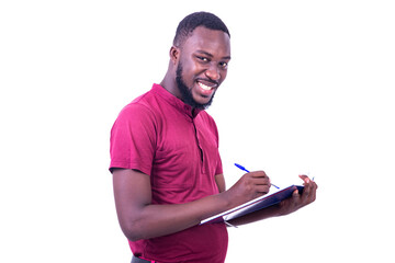 young happy man writing in notebook with pen smiling.
