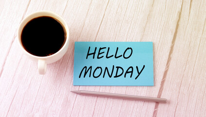 HELLO MONDAY text on the blue sticker with cofee and pen