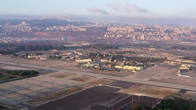 Haifa airport and runway with the city skyline in the background, Aerial view.