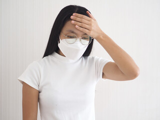 Asian woman touching her forehead, feeling sick, headache, migraine on white background.
