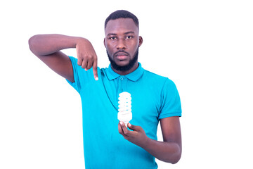 handsome serious young man holding a light bulb and pointing finger down.