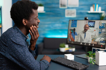 African american patient having painful teeth illness discussing pain treatment with remote doctor...