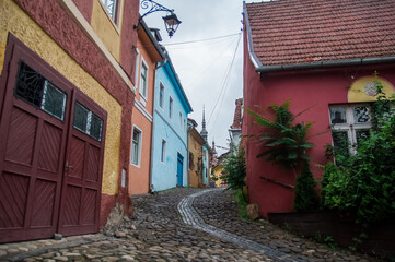 Fototapeta na wymiar Wąska kamienna uliczka z kolorowymi budynkami