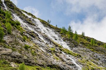Wild alpine waterfall on Schlatenbach mountain stream. Gschloesstal Valley, Hohe Tauern National Park, East Tyrol, Austrian Alps