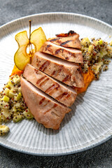 Grilled duck or chicken fillet with squash puree and chia with apples. Ready menu for the restaurant. Neutral gray blue textured background