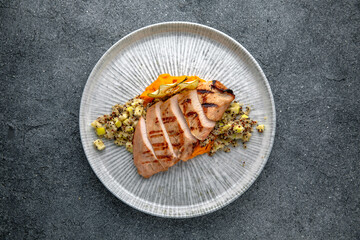 Grilled duck or chicken fillet with squash puree and chia with apples. Ready menu for the restaurant. Neutral gray blue textured background