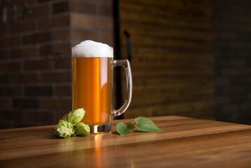Glass of light beer on a dark pub.