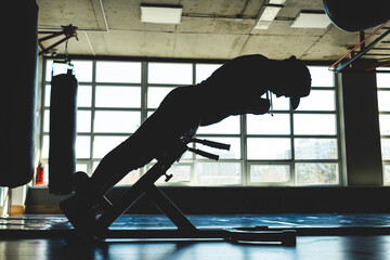 The athlete is training in the gym opposite the window. Abdominal Exercise