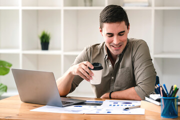 Fototapeta premium confident young businessman Work from home with laptop and documents on the desk.