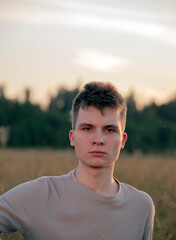 Portrait of a serious young man standing against the background of a forest .