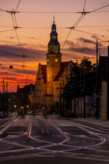 New Town Hall in Olsztyn and Piłsudskiego Street with tracks and electrification lines of city trams, view after sunset