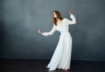 Woman in white dress barefoot dance fun dark background