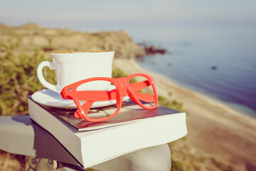 Coffee cup and book outdoors