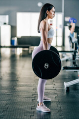 beautiful sporty woman doing squat workout in gym