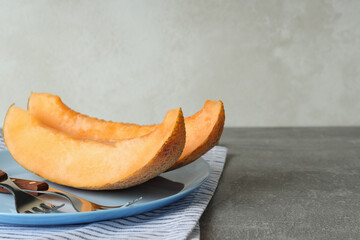 Plate with melon slices on gray textured table