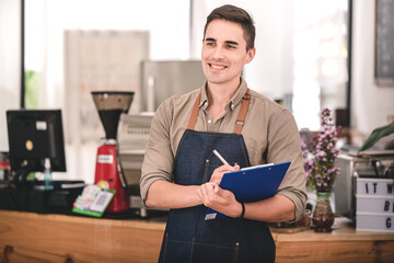Male barista working at a coffee shop ready to order