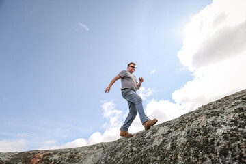 Man running and jumping on rocks in nature