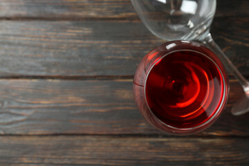 Glass of red wine and empty glass on rustic wooden background