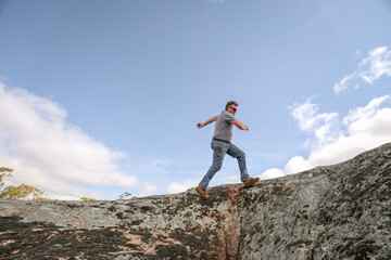 Man running and jumping on rocks in nature