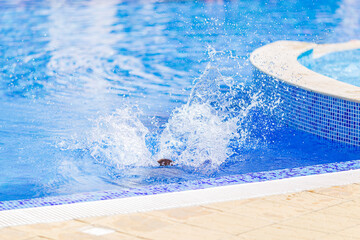 children jump, swim and play in the pool on a beautiful sunny summer day.  fun for kids on sunny summer days. 