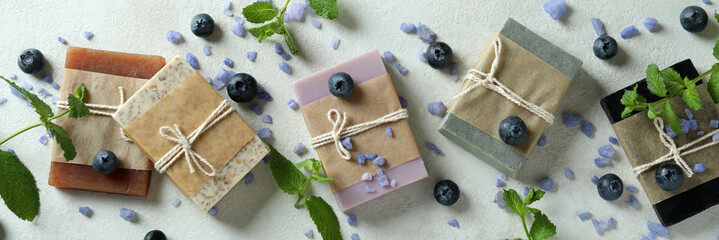 Different natural soap for skin care on white textured table