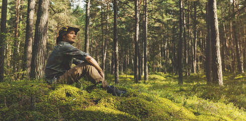 forest ranger or forester sitting on the hill and watching the territory. copy space