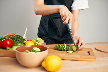 chef in black apron slicing vegetables housework cooking