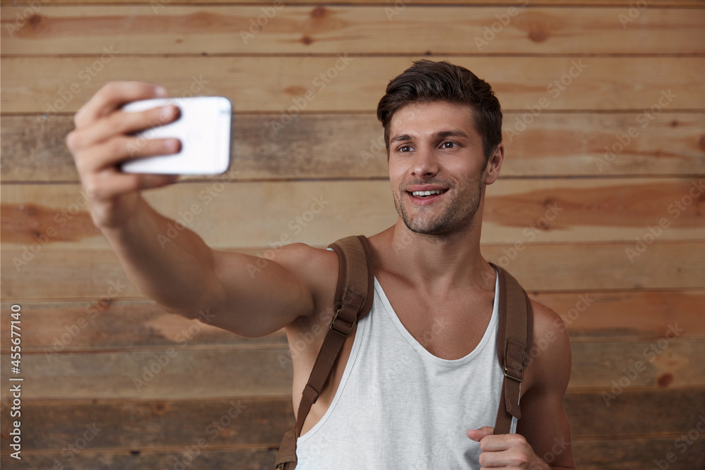 Sticker Young european man taking selfie on mobile phone