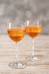 Homemade Aperol spritz. Orange sparkling cocktail in a glass on a wooden table. Vertical image