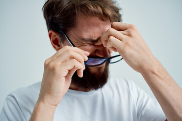 sick man vision problems in white t-shirt light background