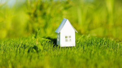  paper house against the background of green grass. climate change. ECO friendly house. 