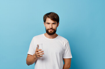 bearded man drinking water blue background