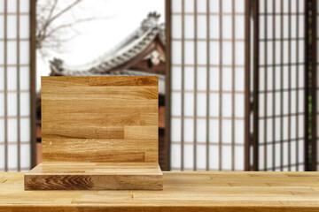 Wooden desk with pedestal for your decoration and free space for your product. Japan blurred window. 