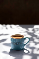 Cup of coffee on grey background, Single cup of coffee. Leaf shadow pattern