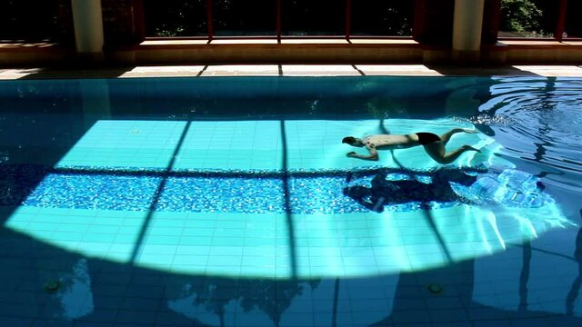Man Swimming Underwater Breaststroke In Luxurious Swimming Pool