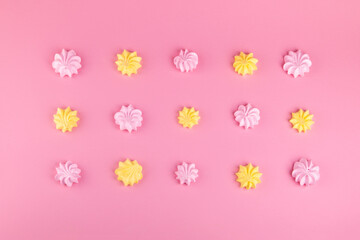Pink and yellow meringues on a pink background. Sweet beze. Food. Dessert. Cookie - obrazy, fototapety, plakaty