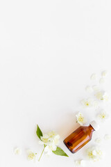 Obraz na płótnie Canvas Jasmine flowers with essence oil bottle. Top view