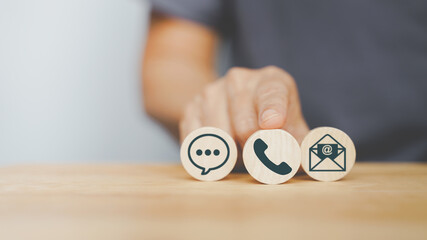 senior hand choose telephone icon on small circle wood for suitable contact method, business call...