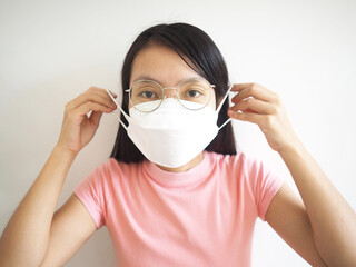 Asian woman showing how to wear a medical mask step by step on white background.